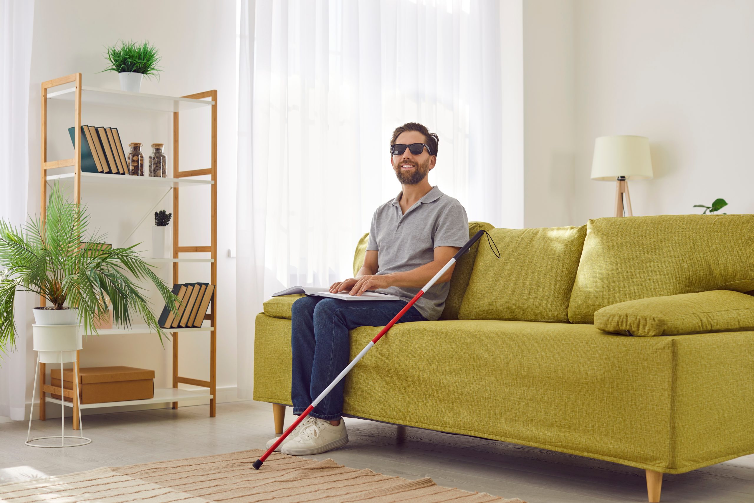 Blind NDIS Participant on couch